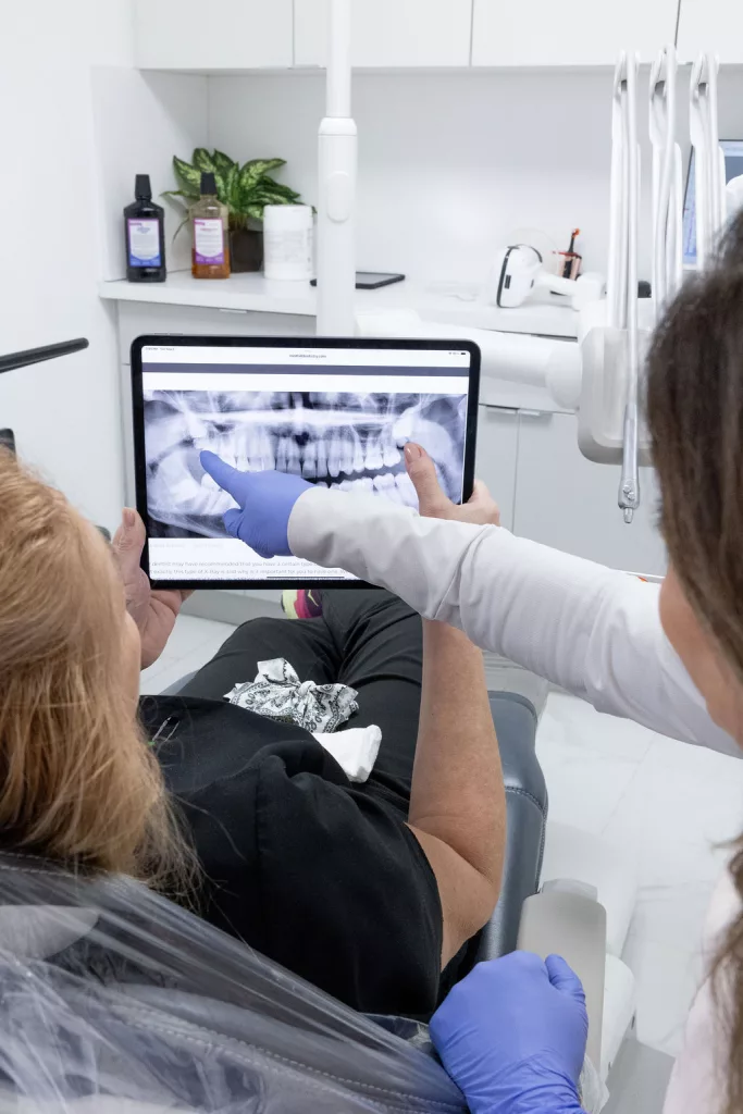 Reviewing a patient's X-ray on a tablet at Dr. G Dental Studio in Miami