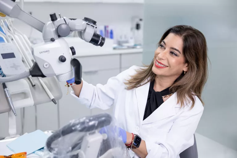 Dr. Yordanka Gonzalez, DMD, working with a dental microscope at Dr. G Dental Studio